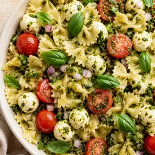 Bow Tie Pasta Salad with pesto, mozzarella, cherry tomatoes, and basil