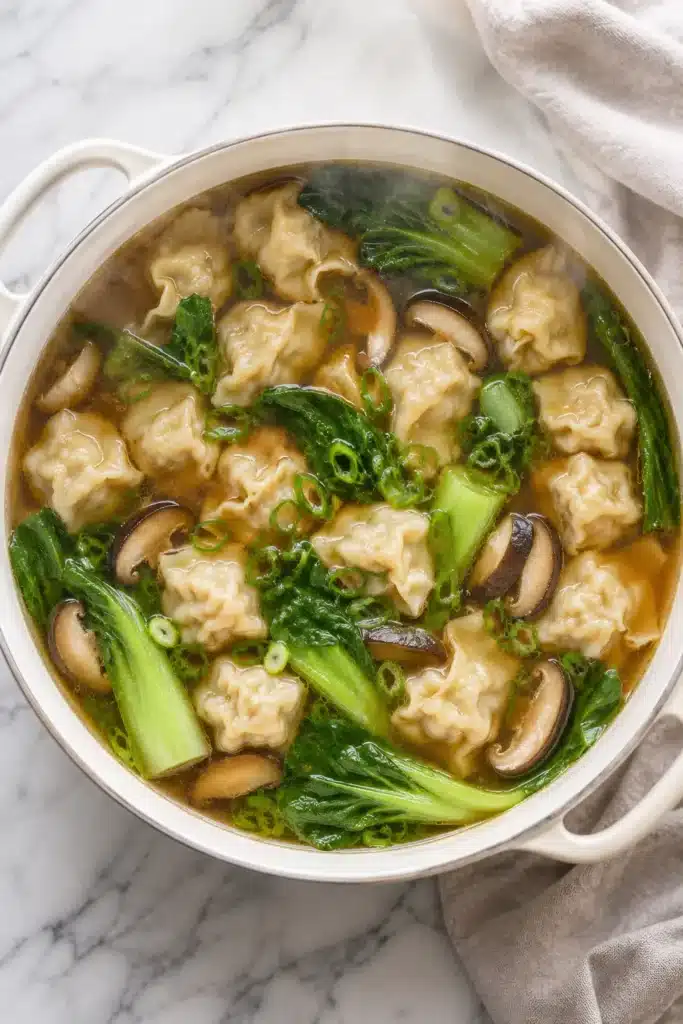 Easy wonton soup cooking with dumplings and vegetables in broth