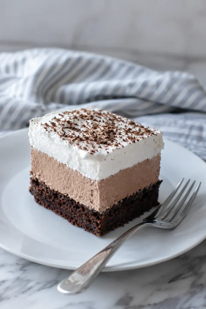 French Silk Brownies slice with creamy topping on white plate
