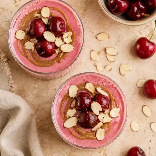 Almond Cherry Smoothie topped with cherries, almond butter, and sliced almonds