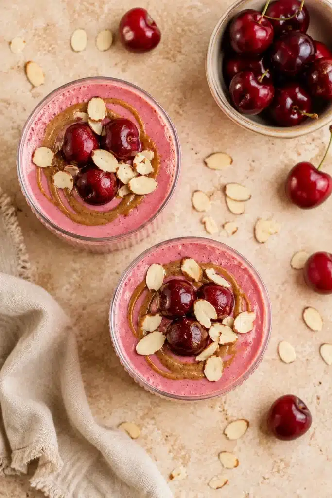 Almond Cherry Smoothie topped with cherries, almond butter, and sliced almonds