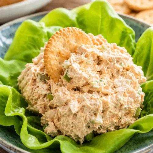 Chicken Salad Chick Buffalo Barclay served on fresh lettuce leaves with a cracker