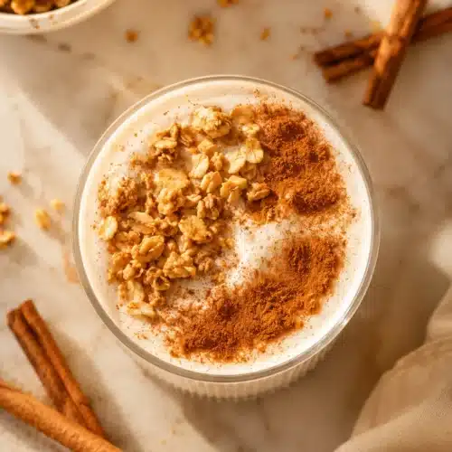 Cinnamon Roll Protein Shake topped with granola and cinnamon