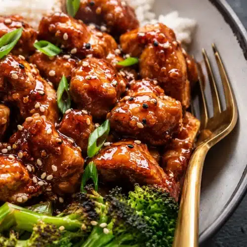 Close-up of Sticky Sesame Chicken with sesame glaze and broccoli
